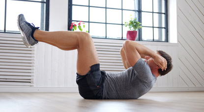 Bauchmuskeln trainieren: Foto von einem Mann beim Bauchtraining auf dem Boden.