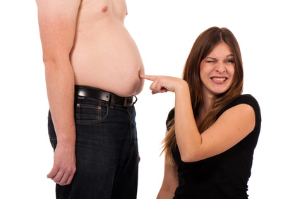 Bauchspeck loswerden: Foto von einem dicken Bauch auf den eine Frau tippt