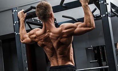 Latissimusübungen: Foto von einerm Mann mit freiem Oberkörper bei Klimmzügen