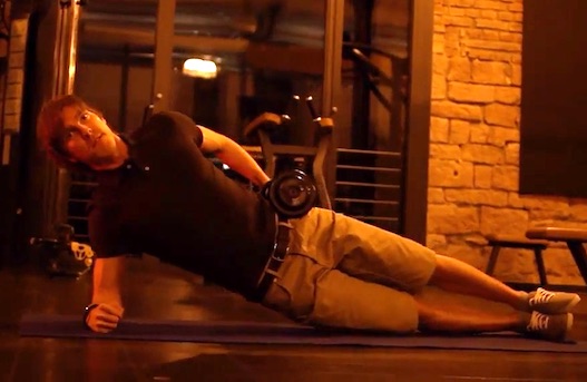 Schräge Bauchmuskeln Übungen: Foto von einem Mann bei der Übung seitliches Hüftheben mit Kurzhantel.